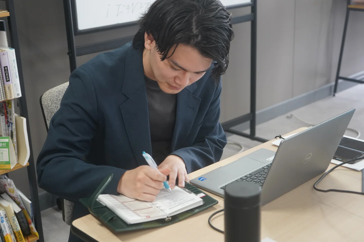 手帳に書き込みをする男性